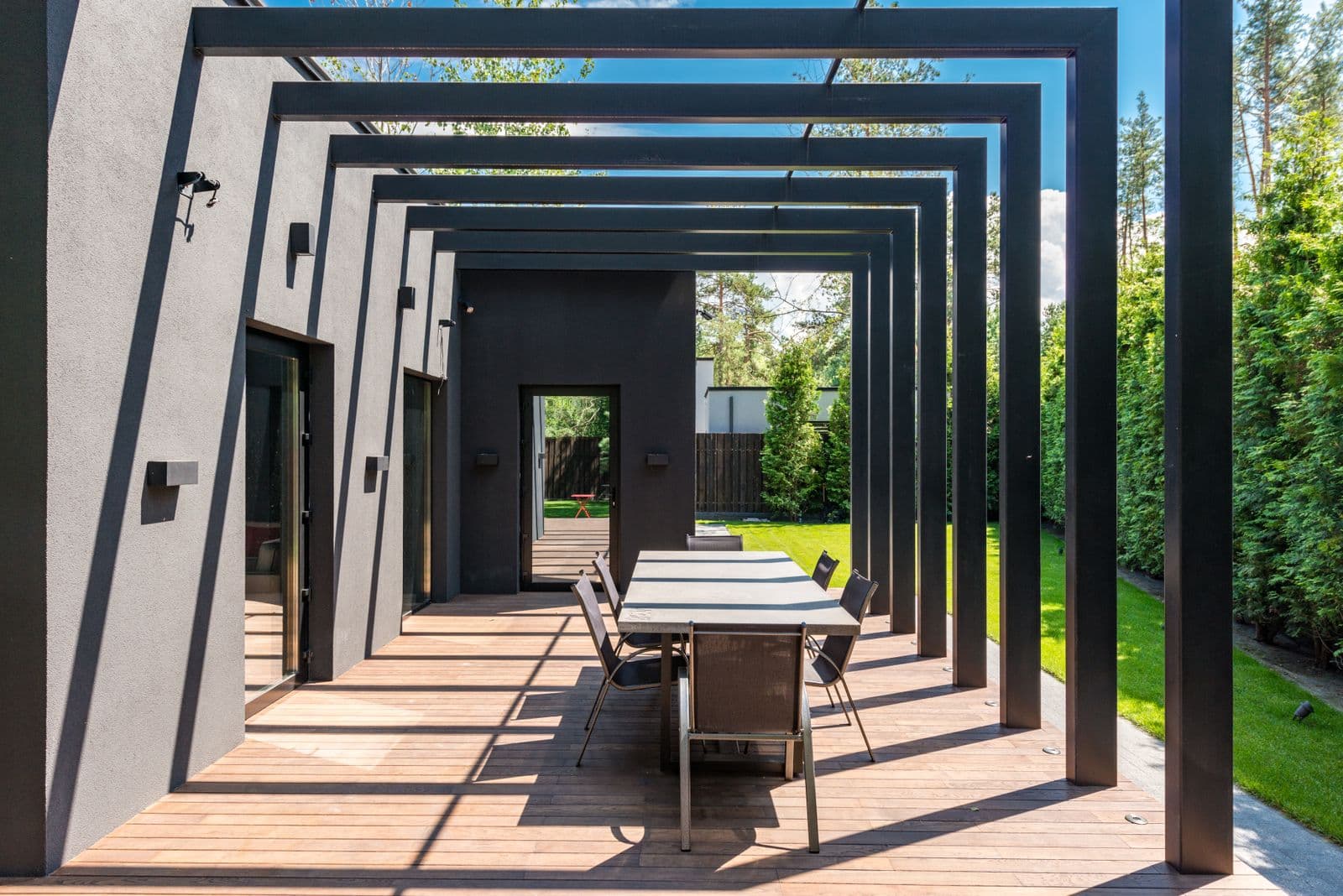 Contemporary patio with wooden pergola and outdoor dining set